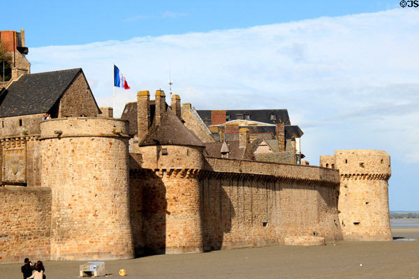 Massive walls & bastions of Mont-St-Michel seen from mud flats at low tide. Mont-St-Michel, France.