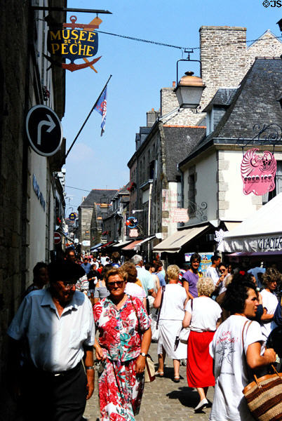 Narrow street in old town crowded with visitors. Concarneau, France.
