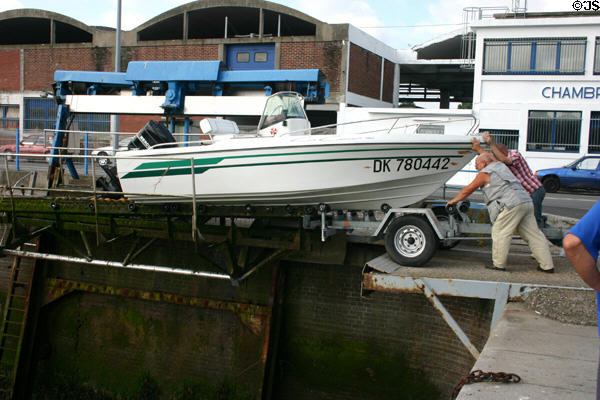 Putting power boat onto lift cradle to lower craft into Dieppe harbor. Dieppe, France.