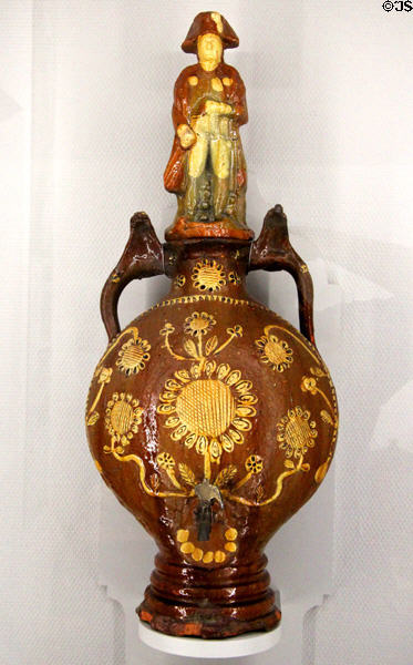 Stoneware water dispenser with top in form of Emperor Napoleon I (19thC) by Vindefontaine potters at Museum of Normandy. Caen, France.