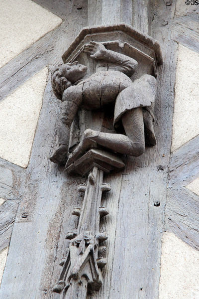 Carving detail of man in Medieval dress bending over backward on Acrobats house. Blois, France.