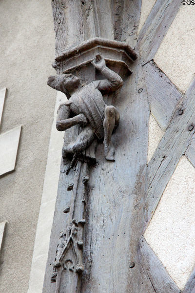 Carving detail of man in Medieval dress holding up structure on Acrobats house. Blois, France.