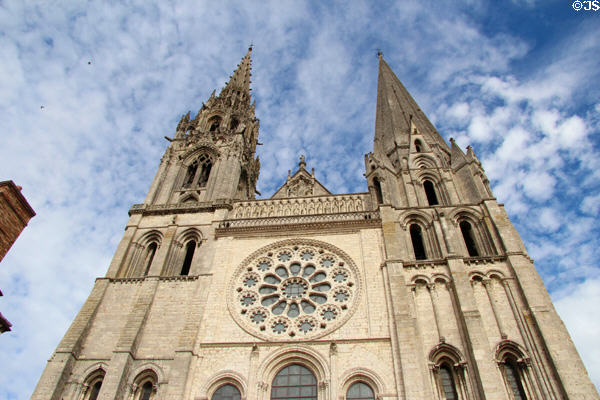 Gothic (1200s) & Romanesque (1100s) bell towers with rose window in between at Chartres Cathedral. Chartres, France.