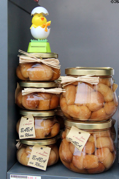 Jars of Baba au Rhum in shop window on Place St Croix. France.
