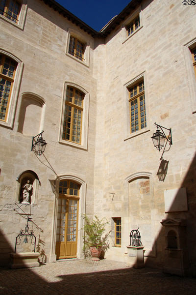 Courtyard of Palais du Roure hung with lamps & bells. Avignon, France.