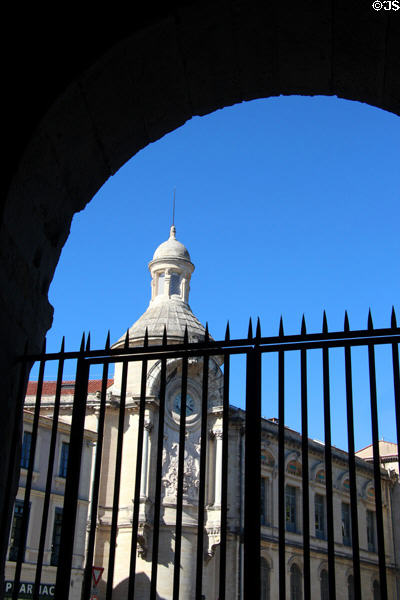 High school building seen through arch of Arena of Nîmes. Nimes, France.