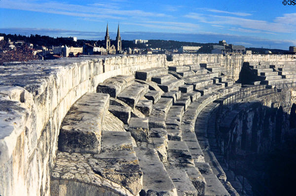 Arena upper tier of seats with town beyond. Nimes, France.