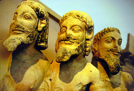 Detail of pediment from earliest Parthenon features three bearded males which are snakes from waist down, holding fire, water, and bird, dates from the 6th century BC in Acropolis Museum. Greece.