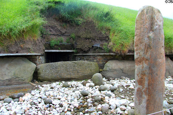 Spiral carved stones & standing stone marking entrance of Main Neolithic passage grave (c3200 BCE) at Knowth. Ireland.