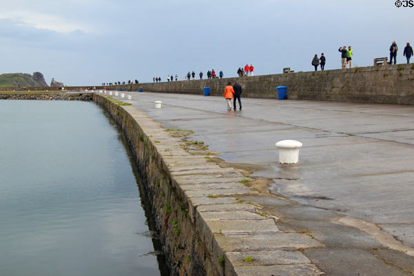 Walking along Howth harbor breakwater. Howth, Ireland.