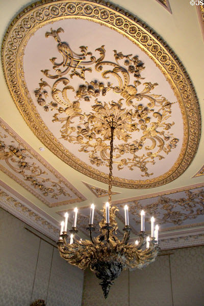 Gilded sculpted ceiling with British themed brass chandelier in state drawing room at Aras an Uachtarain. Dublin, Ireland.