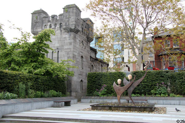 Former coach house towers over Dubblinn Gardens sculptures at Dublin Castle. Dublin, Ireland.