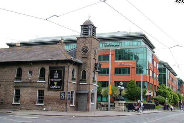 Former Harbour Master building with tower preserved among new office buildings at Custom House Basin built off River Liffey. Dublin, Ireland.