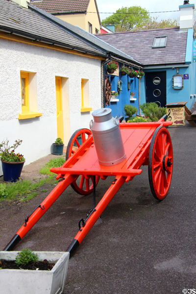 Decorative cart with milk can & vintage cottages in Dingle. Dingle, Ireland.