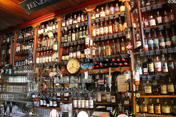 Liquor bottles crowded on shelves at Dick Mack's Pub in Dingle. Dingle, Ireland.