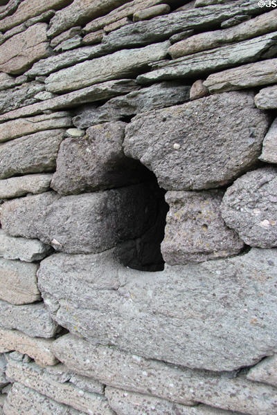 Only window opening, wider on interior than exterior, of Gallarus Oratory on Dingle Peninsula. Ireland.