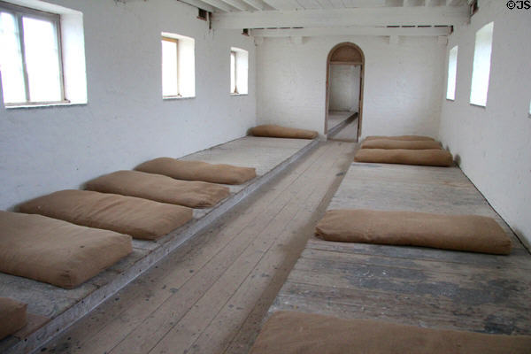 Residents' sleeping quarters with rough mattresses on floor shelf at Irish Workhouse Centre. Portumna, Ireland.