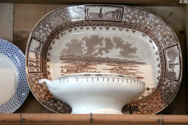 Brown ceramic plate printed with town scene & shamrocks at Strokestown Park. Vesnoy, Ireland.