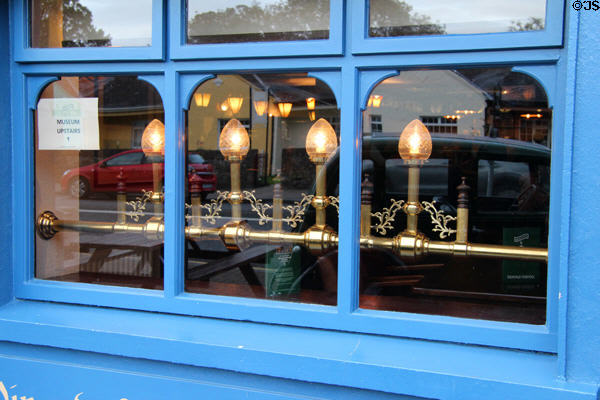 Multi-pane window with brass lights. Adare, Ireland.