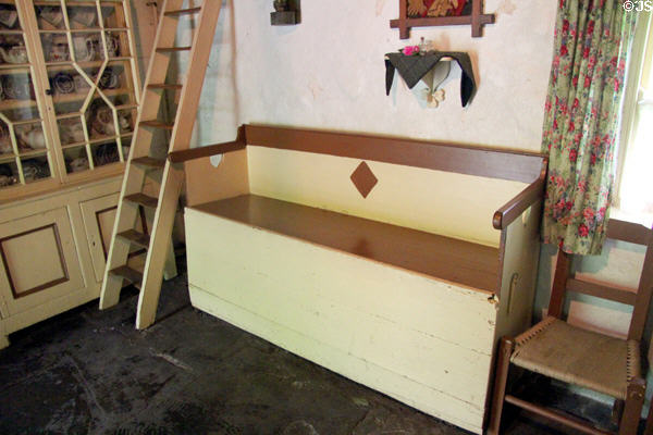 Flag stone floor & decorative storage bench seat & glass fronted cupboard (c1890's) in Mountain Farmhouse at Bunratty Castle & Folk Park. County Clare, Ireland.
