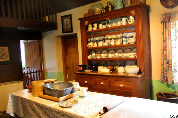 Open wooden cupboard with dishes in Golden Vale Farmhouse kitchen at Bunratty Castle & Folk Park. County Clare, Ireland.