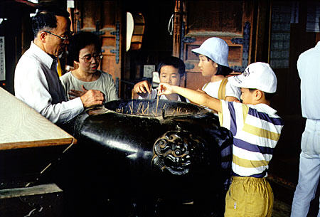 Family burns incense at a temple in Nara. Japan.