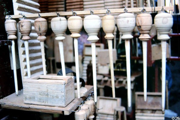 Drop spindle whorl for yarn spinning by hand with top-like mass for momentum. Marrakesh, Morocco.