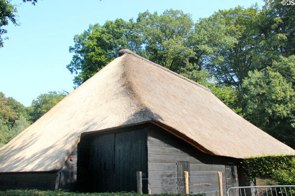 Simple building whose thatched roof structure, technically called eves, extends significantly beyond exterior wall, likely employed to help protect building from rainfall, at Arnhem Openlucht Museum. Arnhem, Netherlands.