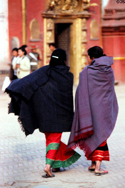 Cloaked women in front of Golden Gate in Durbar Square, Bhaktapur. Nepal.