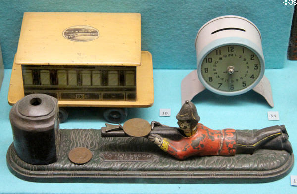 Soldier firing penny into vault on mechanical Wimbledon Bank & other coin banks at Museum of Childhood. Edinburgh, Scotland.