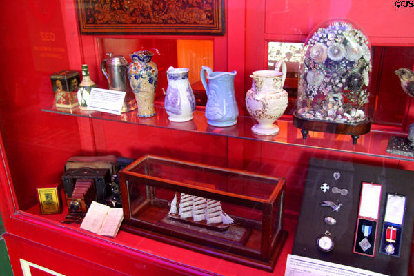 Pawn shop window display with ceramic pitchers & other merchandise at Riverside Museum. Glasgow, Scotland.