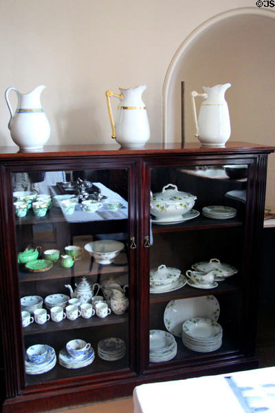 Glass fronted cupboard with pitchers & table ware in kitchen at Lauriston Castle. Edinburgh, Scotland.