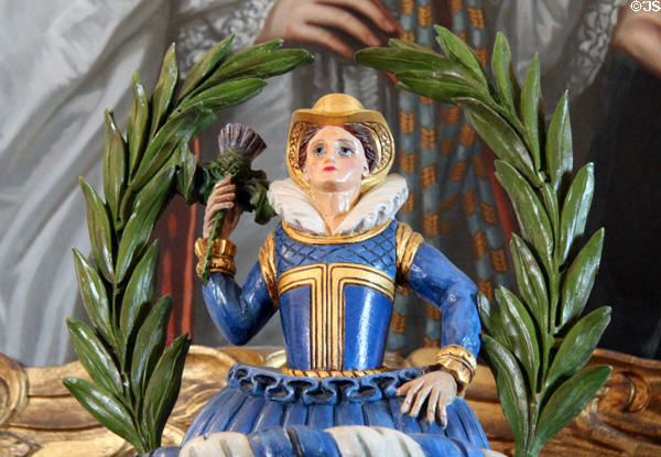 Detail of carved woman holding thistle atop carved & painted chest in great hall at Glamis Castle. Angus, Scotland.