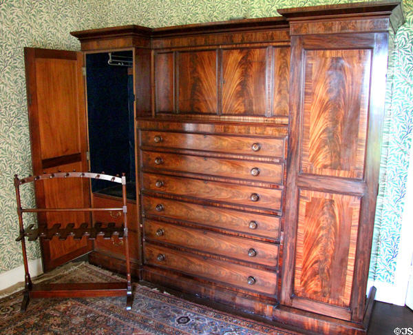 Late Georgian ecclesiastical wardrobe, boot rack & William Morris wallpaper in dressing room at Kellie Castle. Pittenweem, Scotland.