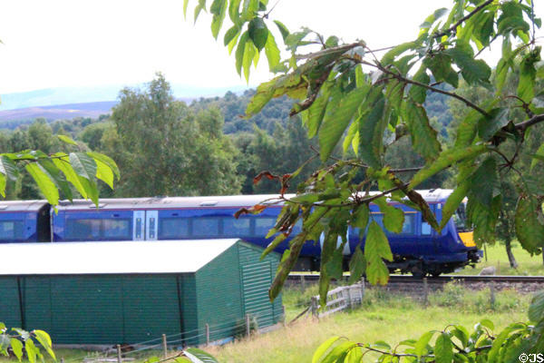 Passenger train passing Highland Folk Museum. Newtonmore, Scotland.