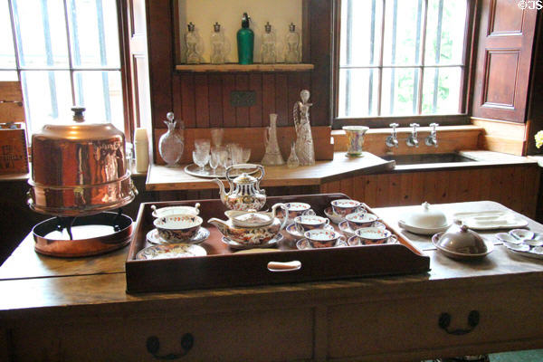 Tea service on tray beside copper hot-water dispenser in butler's pantry at Fyvie Castle. Turriff, Scotland.