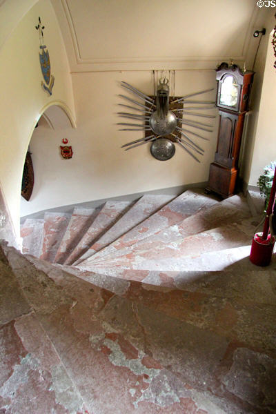 Grand spiral staircase with tall clock in corner at Fyvie Castle. Turriff, Scotland.
