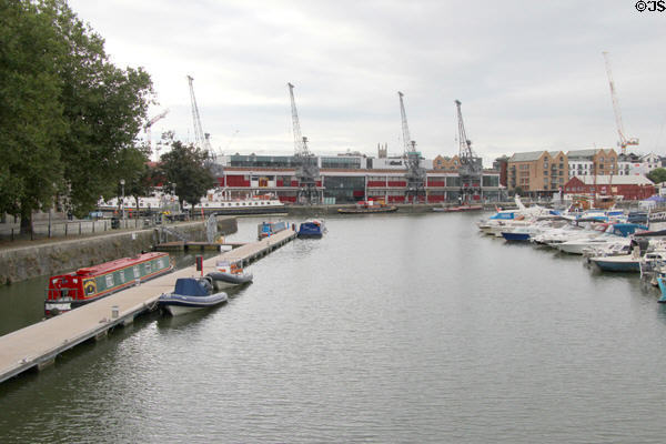 View of warehouses & cranes once used to receive goods from ships docking at Floating Harbour. Bristol, England.