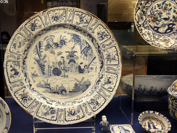 Exceptionally large English delftware dish (1703) with painting inspired by Chinese porcelain from late Ming Dynasty likely made for celebration of a marriage, likely made in Brislington, at Bristol Museum & Art Gallery. Bristol, England.