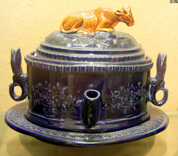 Whimsical earthenware, blue-glazed teapot with cow on lid (c1870) made by J & J White, Baptist Mills Pottery at Bristol Museum & Art Gallery. Bristol, England.