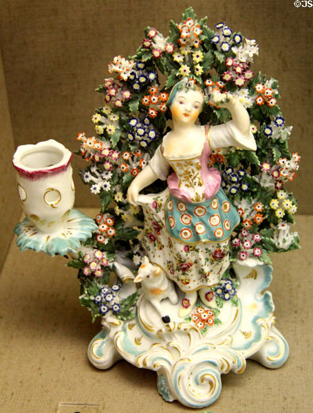 Porcelain candlestick (c1760), one of pair over-glaze-painted & gilded with Rococo scene of shepherd (not shown) & shepherdess, made in Chelsea at Bristol Museum & Art Gallery. Bristol, England.