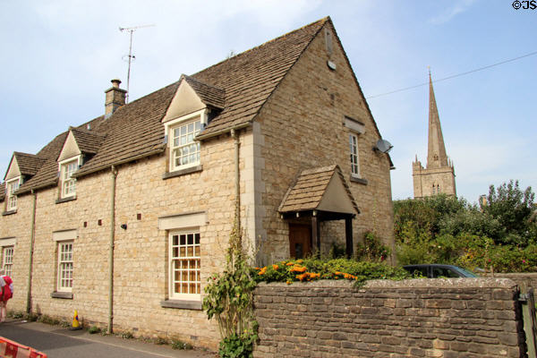 Typical heritage home with church spire in distance. Burford, England.