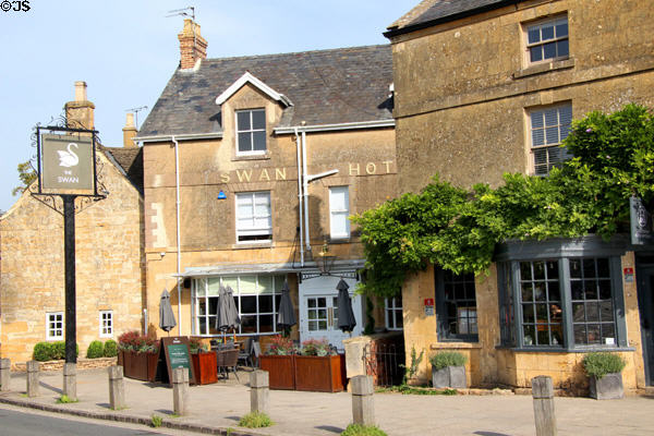 Swan Hotel on The Green with antique shop next door. Broadway, England.