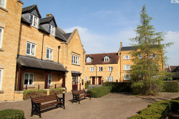 Small park surrounded by buildings constructed in honey colored stone. Broadway, England.