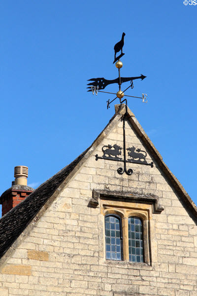 Ornate weather vane topping gabled roof of heritage building. Broadway, England.