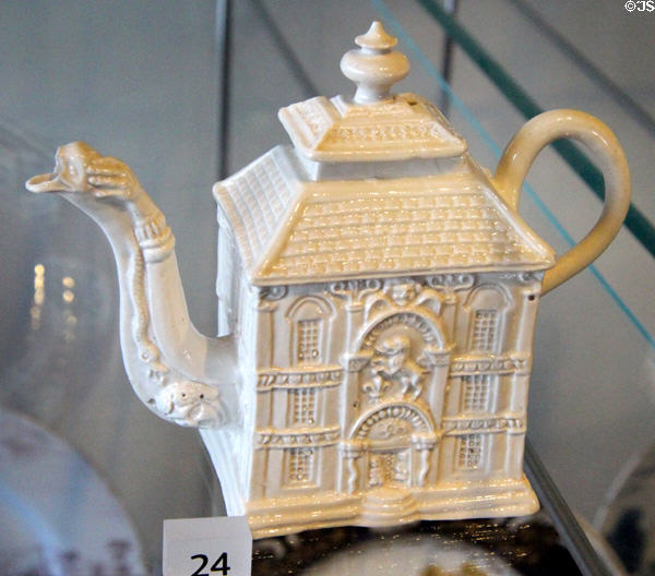 Staffordshire Teapot (c1745-1750) in shape of mansion with dragon spout draped by human arm at Broadway Museum & Art Gallery. Broadway, England.