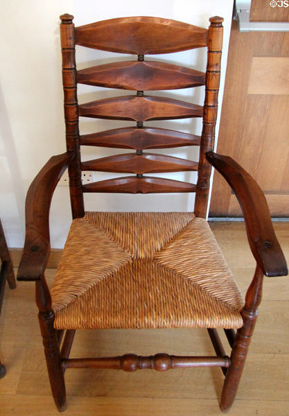 Turned arm chair in yew wood (1928) with rush seating & bog oak bobbins (legs) designed by Gordon Russell at Gordon Russell Design Museum. Broadway, England.