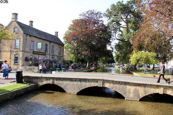 Stone footbridge crossing River Windrush in town center. Bourton-on-the-Water, England.