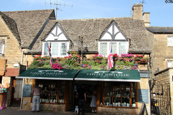 Shop on main street adorned with roof garden and British flags. Bourton-on-the-Water, England.