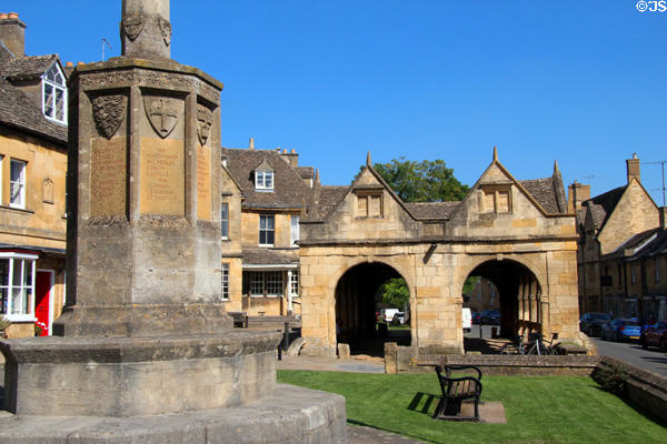 War memorial (1929) to men of town who died during WWI with market hall in background on High St. Chipping Campden, England.